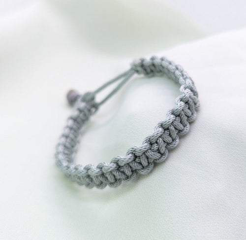 Grey paracord bracelet in a chunky cobra weave with an adjustable cord closure